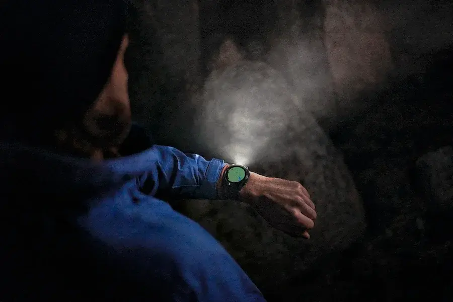Corredor nocturno con la linterna LED del Garmin Fénix 7 Pro iluminando la oscuridad