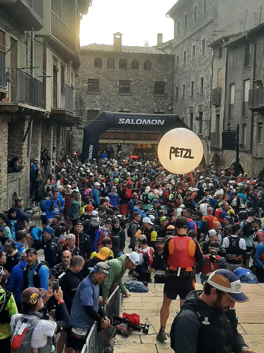 Multitud de corredores esperando en la salida de la Salomon Marató Pirineu, bajo un arco con el logo Salomon y un globo publicitario de Petzl